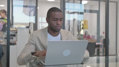 African Man Leaving Office after Working on Computer