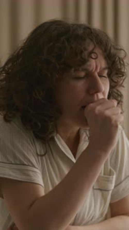 Woman Coughing with Hands on Throat while Feeling Sick at Home