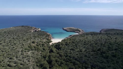 Aerial view of tranquil bay with azure water and sandy beach, Spain.
