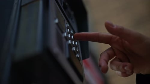 Lowangle View of Finger Pressing Button on Intercom Keypad Located on Building Exterior Allowing