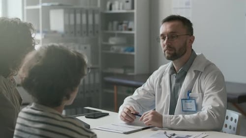 Doctor Providing Medical Consultation to Mother and Son in Clinic