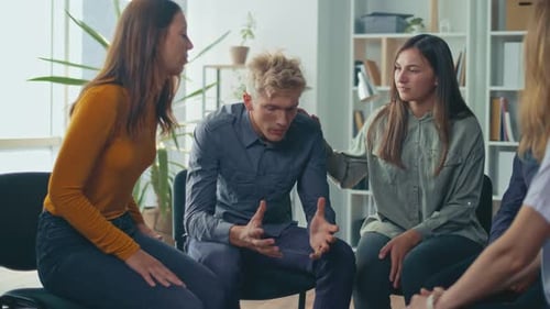 Group of People Sitting in a Circle Supporting Each Other During Group Therapy