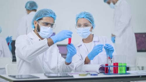 Team of medical professionals wearing protective gear carefully inspect test