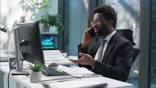Man Talking on Phone at Desk in Modern Office