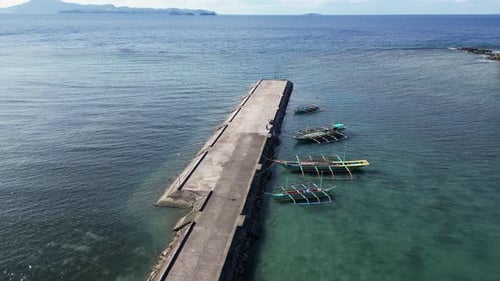 Los barcos de pesca tradicionales del sudeste asiático están amarrados en un muelle de hormigón, día soleado