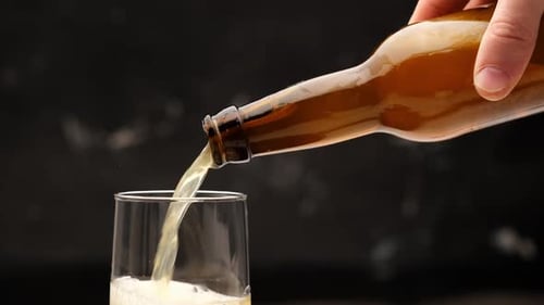 Pouring Beer From Bottle Into Glass