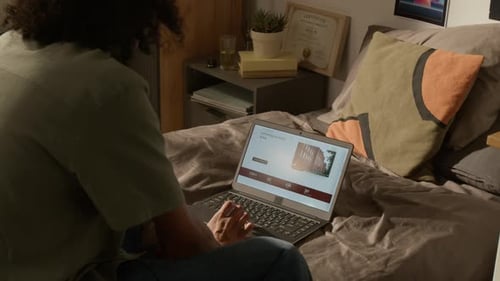 Étudiant noir utilisant un ordinateur portable pour rechercher des programmes universitaires en ligne