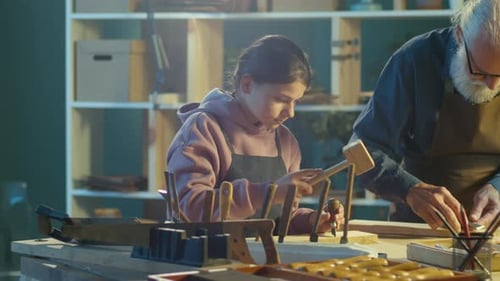 Grandfather Carpenter with His Teenage Granddaughter Works in the Workshop