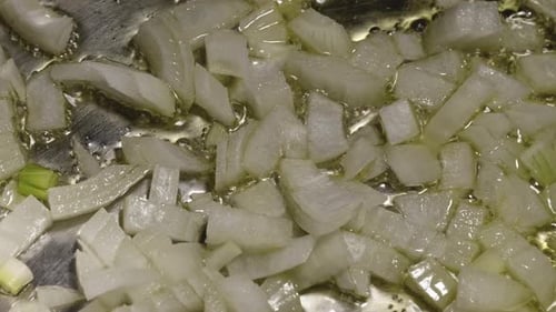 Close-up View of Chopped Onion Sauteing in Pan with Olive Oil, Cooking Pasta Bolognese - Steady Shot