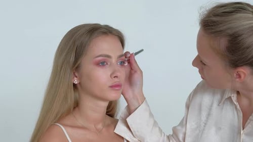 Blonde Woman Having Makeup Applied in Studio