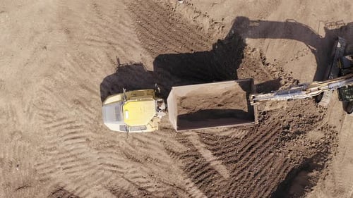 Excavator loading soil onto a Truck, Aerial view.