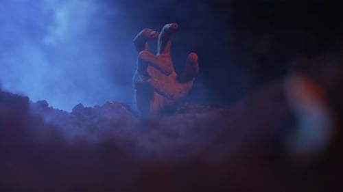 Hand Reaching From Ground In Smoky Blue Light
