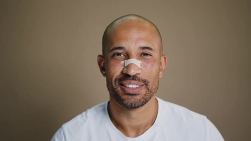 Man Smiling After Nose Surgery with Bandage