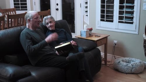 Senior retired husband and wife reading a book together