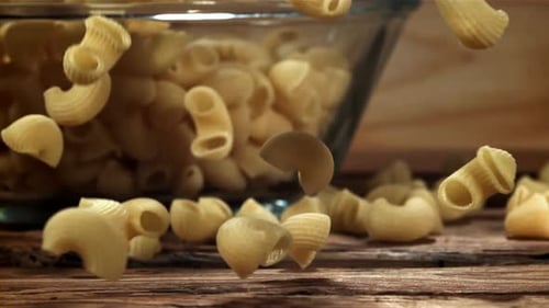 Dry Pasta Falls on a Wooden Table Filmed on a Highspeed Camera at 1000 Fps