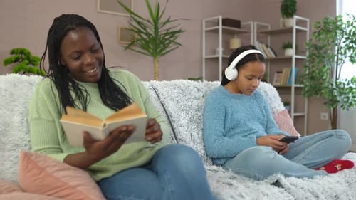 Woman and Girl Relaxing on Sofa Indoors