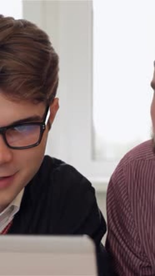 Young Men Collaborating on Project in Bright Office