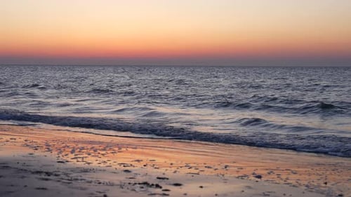 Sunset Beach With Rolling Waves Onto Shoreline. Timelapse
