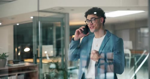Happy Young Man Talking on Smartphone in Modern Office
