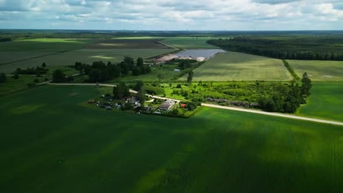 Aerial View of a Countryside Farm with Lush Fields Under a Blue Sky Capturing the Essence of Rural