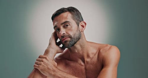 Handsome Man Poses Shirtless Against Light Background