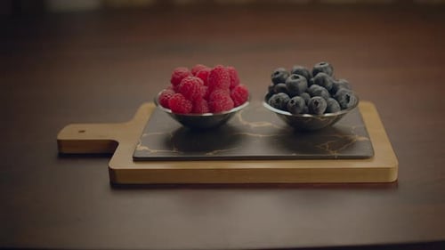 Fresh Raspberries and Blueberries in Bowls on Board