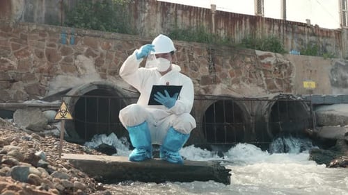Ecologist Sampling Water of Toxic Chemicals From River Checking List and Write to Clipboard Paper