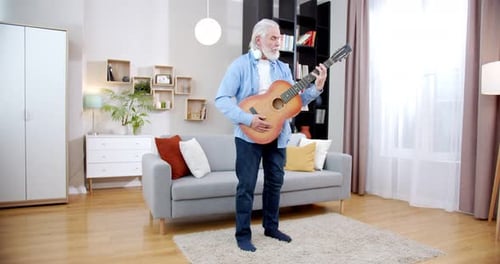 Senior Man Playing Guitar in Living Room