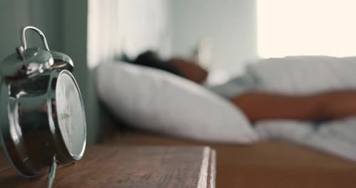 Wecker, Nickerchen und müde Frau, die in ihrem Schlafzimmer schläft und sich erschöpft, verkatert und schläfrig fühlt