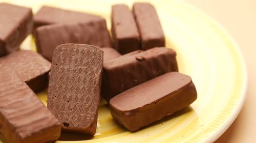 Dark Chocolate on a Yellow Color Plate on Table Close Up
