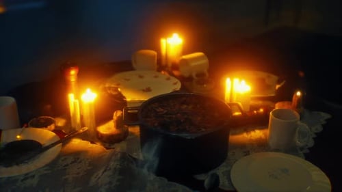 Warm Candlelit Table Setting with Plates and Food