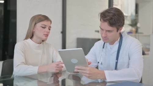 Doctor Consults with Patient Using Digital Tablet
