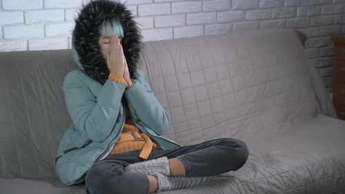 Freezing Girl en veste sur canapé