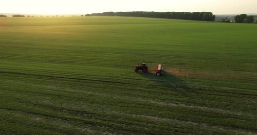 Tractor on an Agricultural Field During Sunset Aerial View