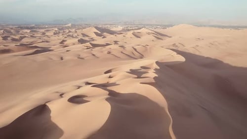 Aerial shot of desert sand dunes against sky, idyllic view of arid desert landscape - Huacachina, Pe