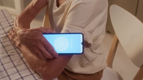 Senior Using Phone to Check Glucose Levels at Home