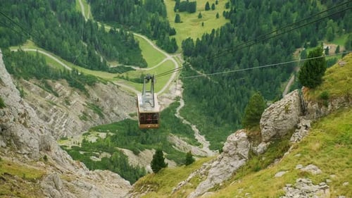Cable Car Cabin Moves Above Forestry Valley in Mountains