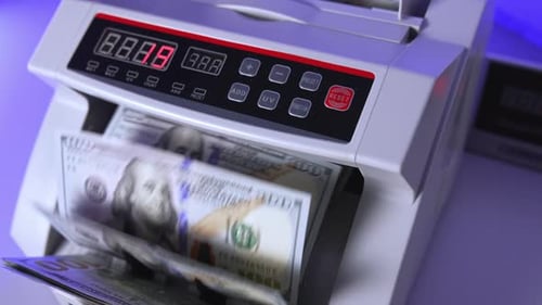 100 US dollar in money counting machine in action, close up