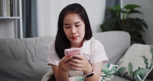 Attractive Woman Using Cell Phone on Sofa