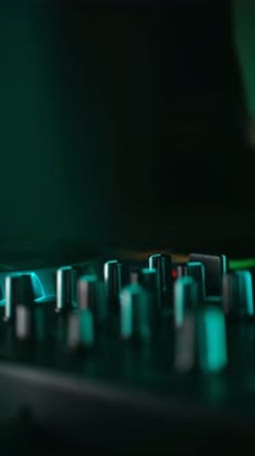 Sound Engineer Adjusting Knobs on Audio Mixer