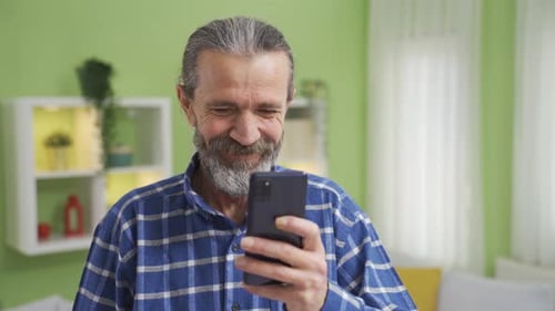 Senior Man Using Smartphone in Bright Home Interior