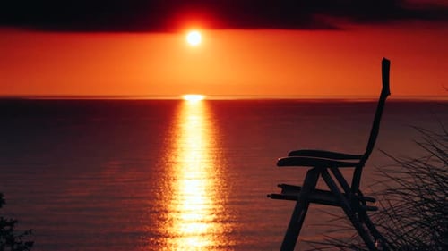 Camp Chair on Beach and Sunrise over Sea.