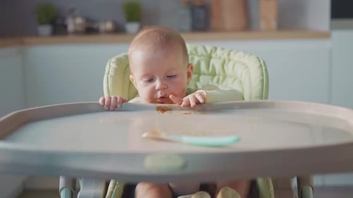 Baby Reaches for Food in High Chair