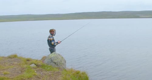 Man Fishing In The Lake In The Early Morning. - wide shot