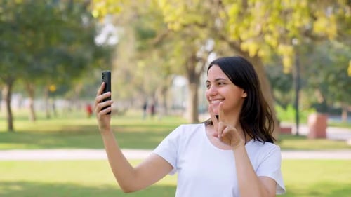 Smiling Woman Using Smartphone in City Park