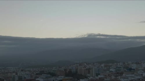 Die Sonnenstrahlen durchdringen im Morgengrauen die dunklen Wolken über der Silhouette der Jaén-Berge