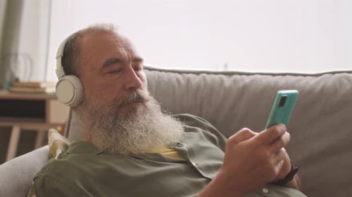 Senior Man Relaxing with Headphones and Mobile Phone