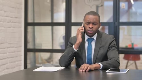 African Businessman Talking on phone in Office