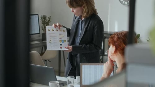 Business Colleagues Discussing Charts and Graphs in Office