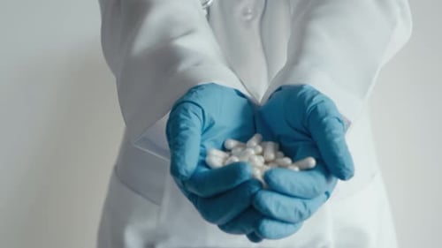 In a Clinic a Healthcare Professional Wearing Sterile Medical Gloves Demonstrates Treatment